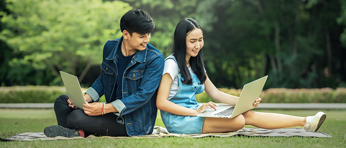 Two younger people reading a market research guide on a laptop