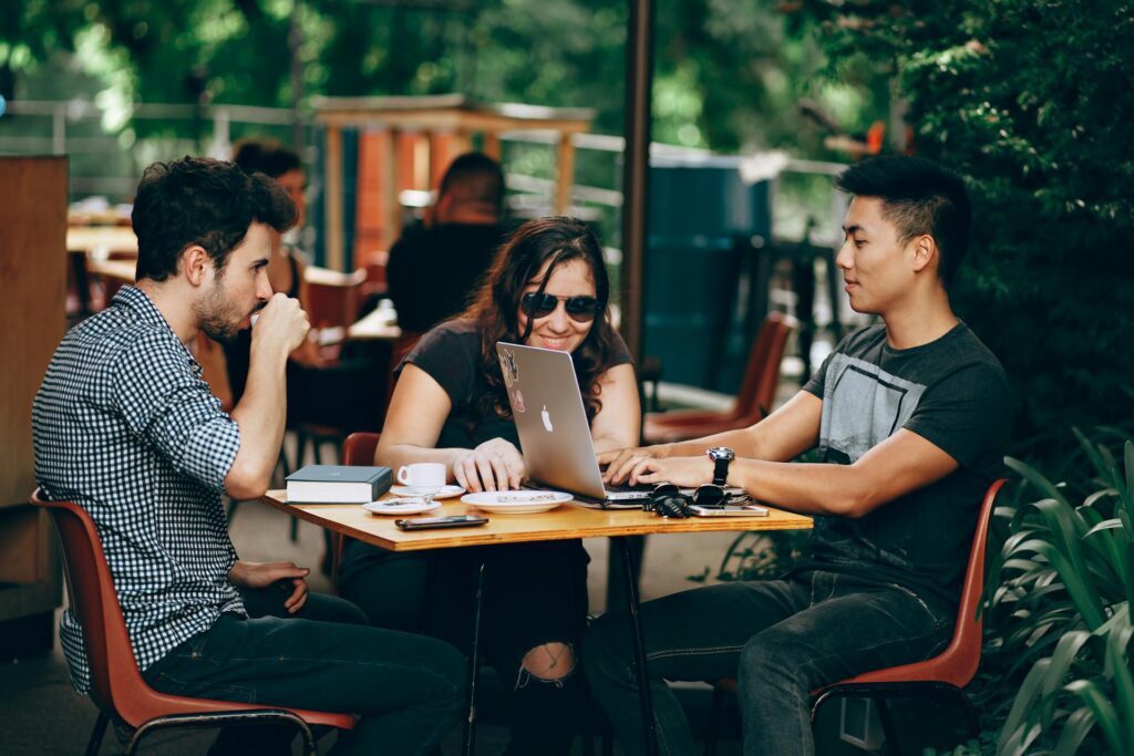 A person who’s using a loyalty management platform while sitting outside with friends