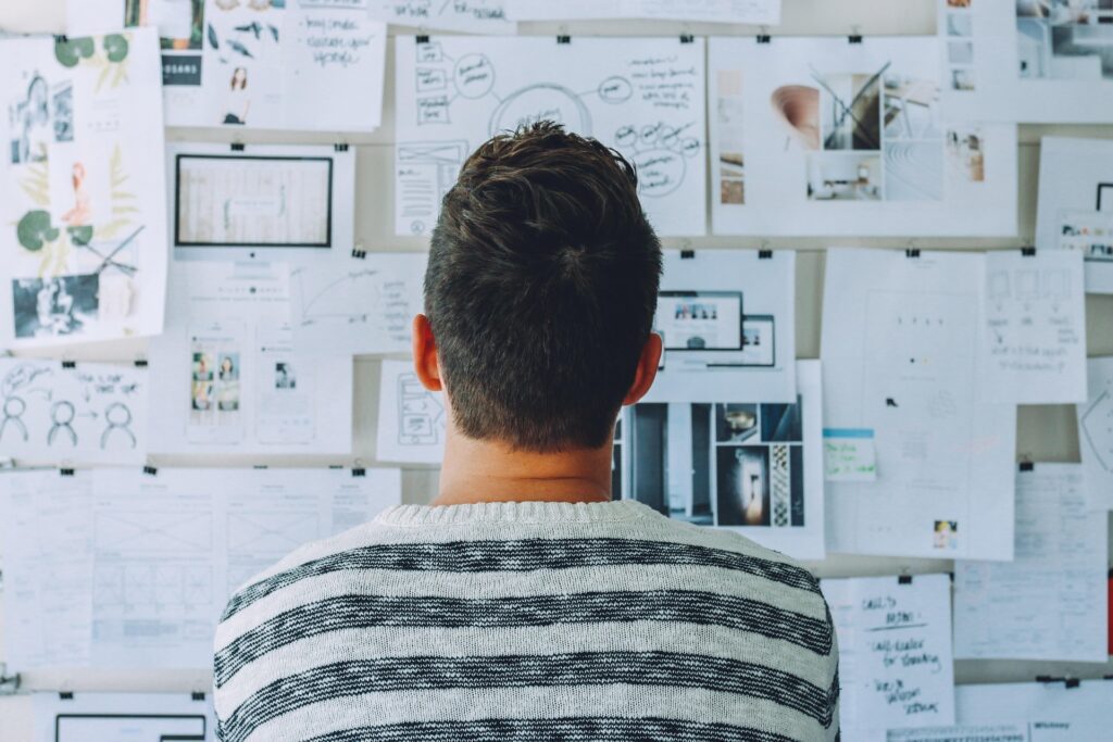 A person looking at papers on a wall to help during the vendor selection process