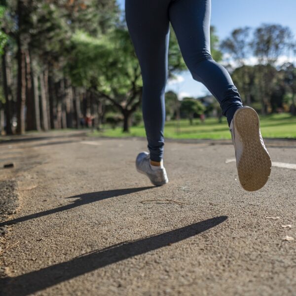 A woman running on a concrete path in a park