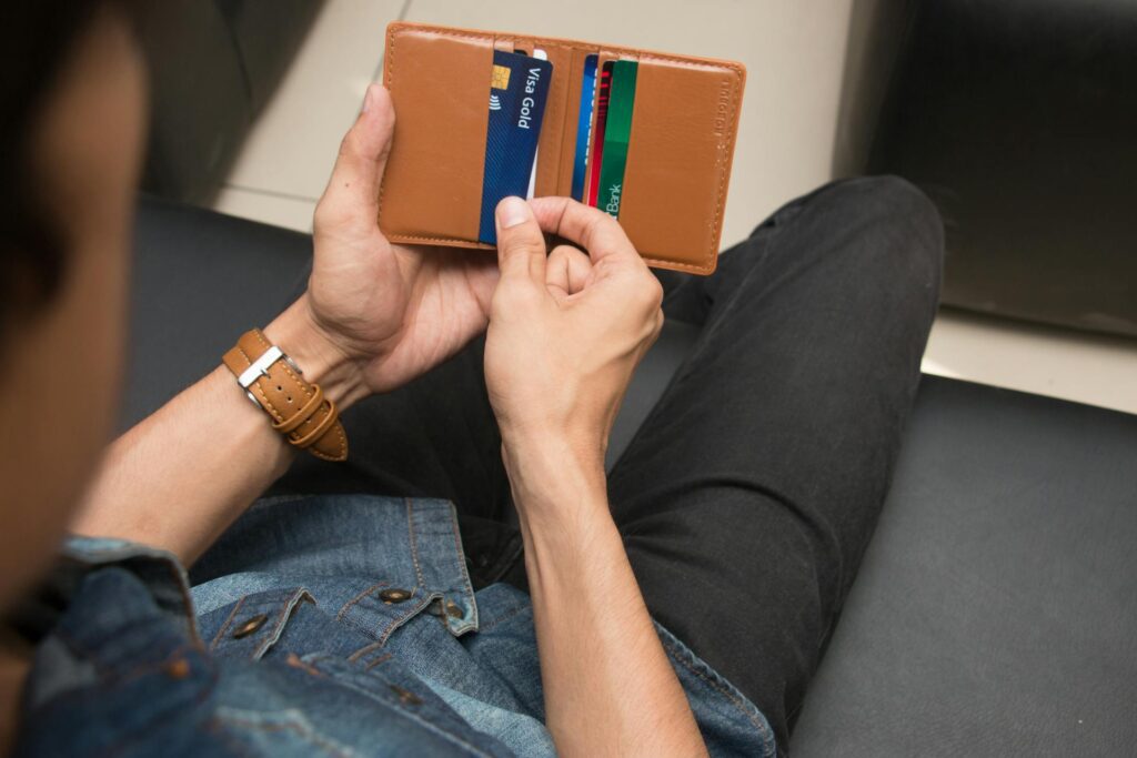 A person pulling a card out of their wallet that’s the physical equivalent to a virtual Visa prepaid card