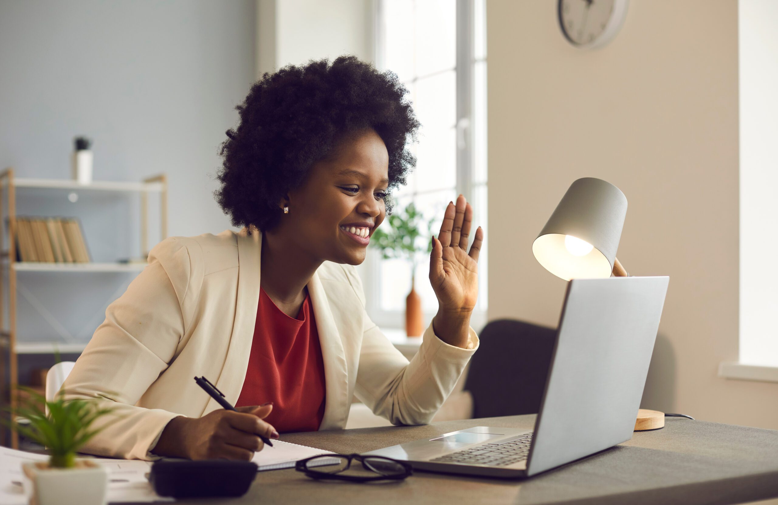 A virtual team meeting with smiling, diverse participants in a modern remote workplace setting, emphasizing human connection in hybrid work