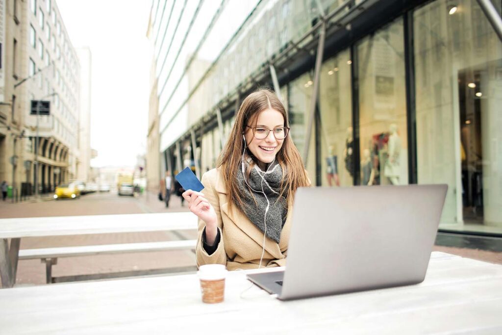 A happy shopper using a laptop to navigate a rebate fulfillment program