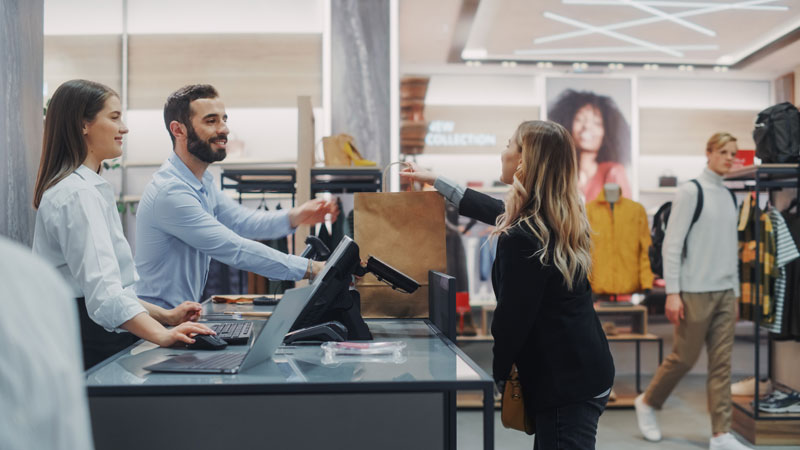 Retail-employee-promoting-an-add-on-product-to-a-customer Retail employee promoting an add-on product to a customer.