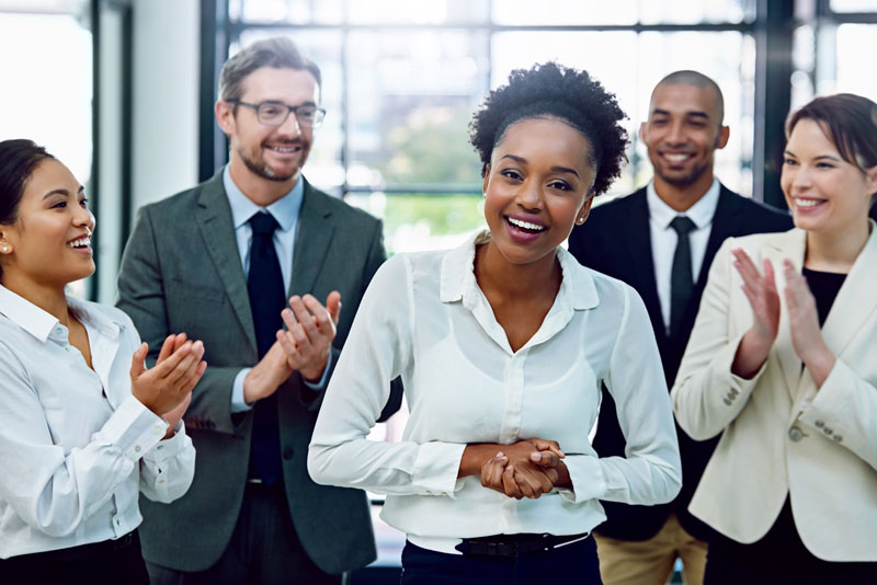 A team celebrating an employee's achievements with recognition and applause.