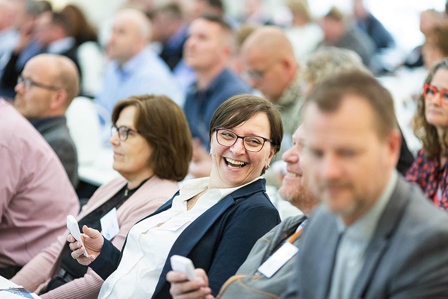 A group of corporate attendees talking about an employee rewards system